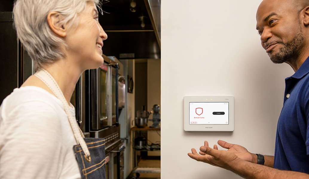 ASAP Security technician demonstrating a First Alert security panel to a homeowner